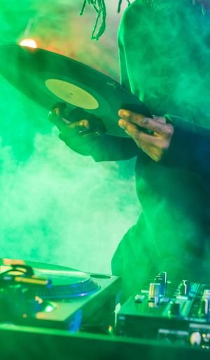 cropped view of male DJ with sound mixer and vinyl on concert cropped view of male DJ with sound mixer and vinyl on concert